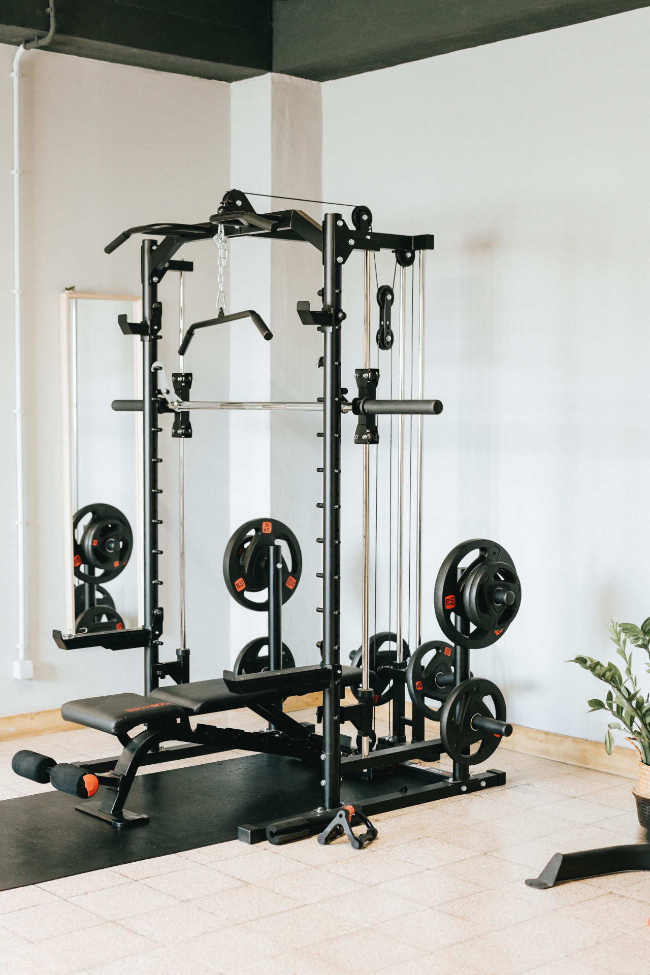 Smith machine com lat pull down, banco e discos no ginásio da Vibrant Health Academy
